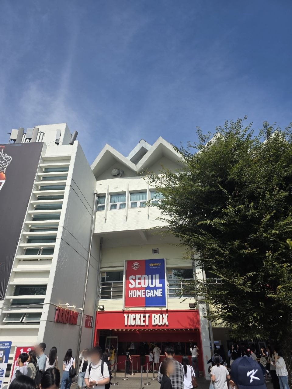 잠실학생체육관 매표소 입구 — 서울 SK와 서울 삼성 색을 반씩 섞은 SEOUL HOME GAME 간판 아래 TICKET BOX 앞에 관중이 모여 있는 모습