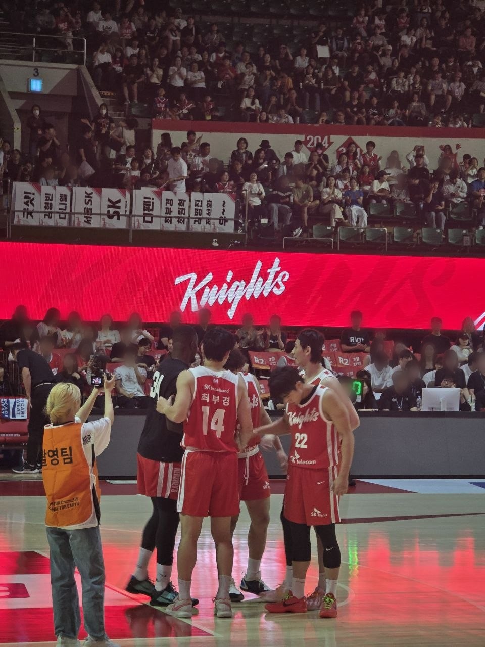 Knights 글자가 뜬 전광판 앞에서 빨간 유니폼의 서울 SK 선수들이 코트에 모여 있는 모습