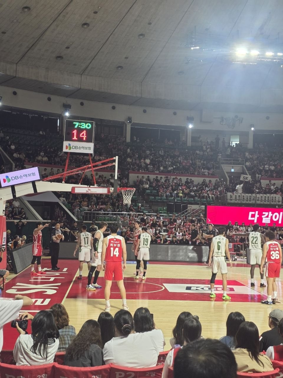 SK 로고가 그려진 코트에서 자유투 상황, 빨간 유니폼 SK 선수들과 흰 유니폼 DB 선수들이 레인에 늘어선 모습