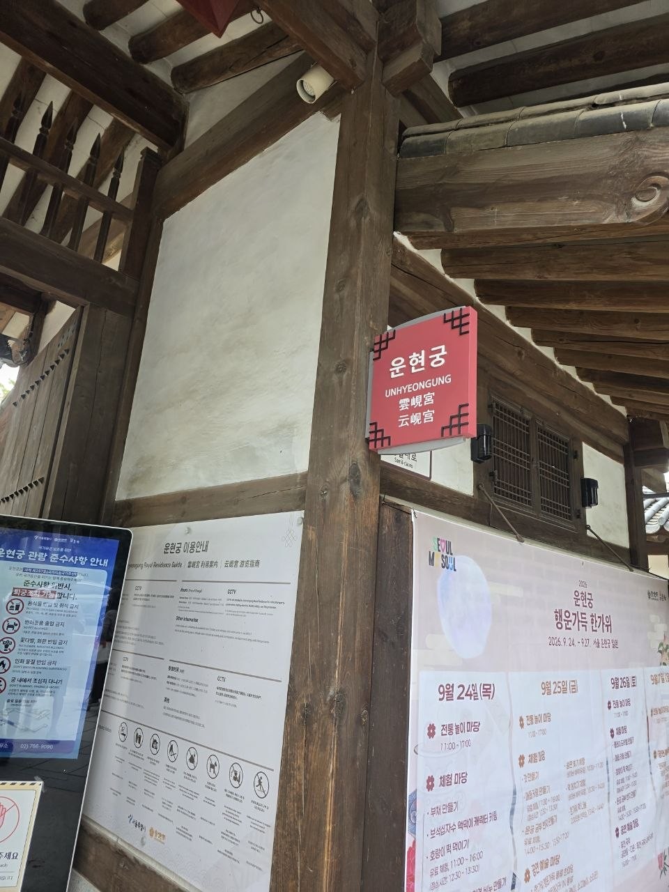 운현궁 입구의 빨간 현판과 그 아래 붙은 2026 운현궁 행운가득 한가위 행사 일정표, 9월 24일 전통놀이 마당과 체험 마당 시간이 적혀 있는 모습