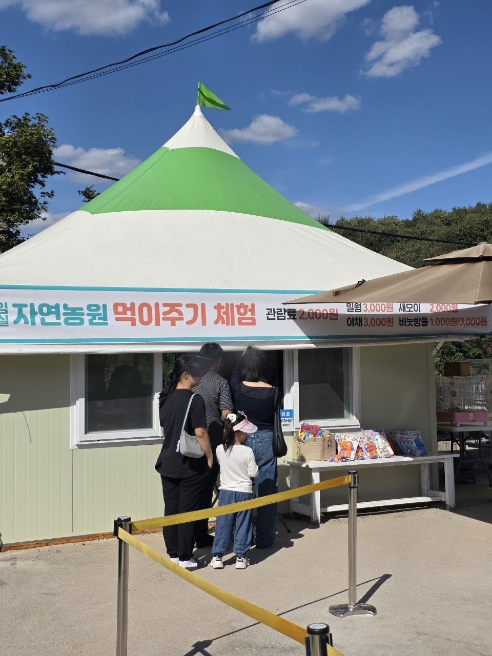 임실 자연농원 먹이주기 체험 매표 천막 — 관람료 2,000원, 밀웜 3,000원, 새모이 2,000원, 야채 3,000원, 비눗방울 1,000원·3,000원 안내