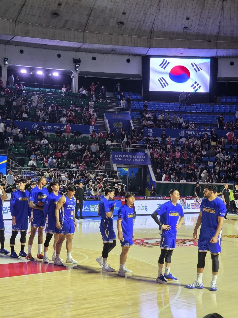 경기 전 국민의례를 위해 코트에 한 줄로 선 서울 삼성 선수들과 전광판의 태극기
